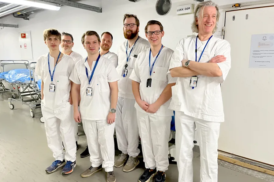 Bildet viser en gruppe IT-eksperter fra Sykehuspartner som er på besøk ved Sørlandet sykehus. Alle er kledd i hvitt sykehustøy.
