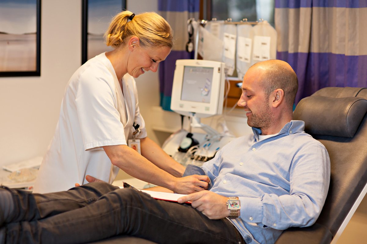 En sykepleier gjør klart for å tappe blod fra pasient