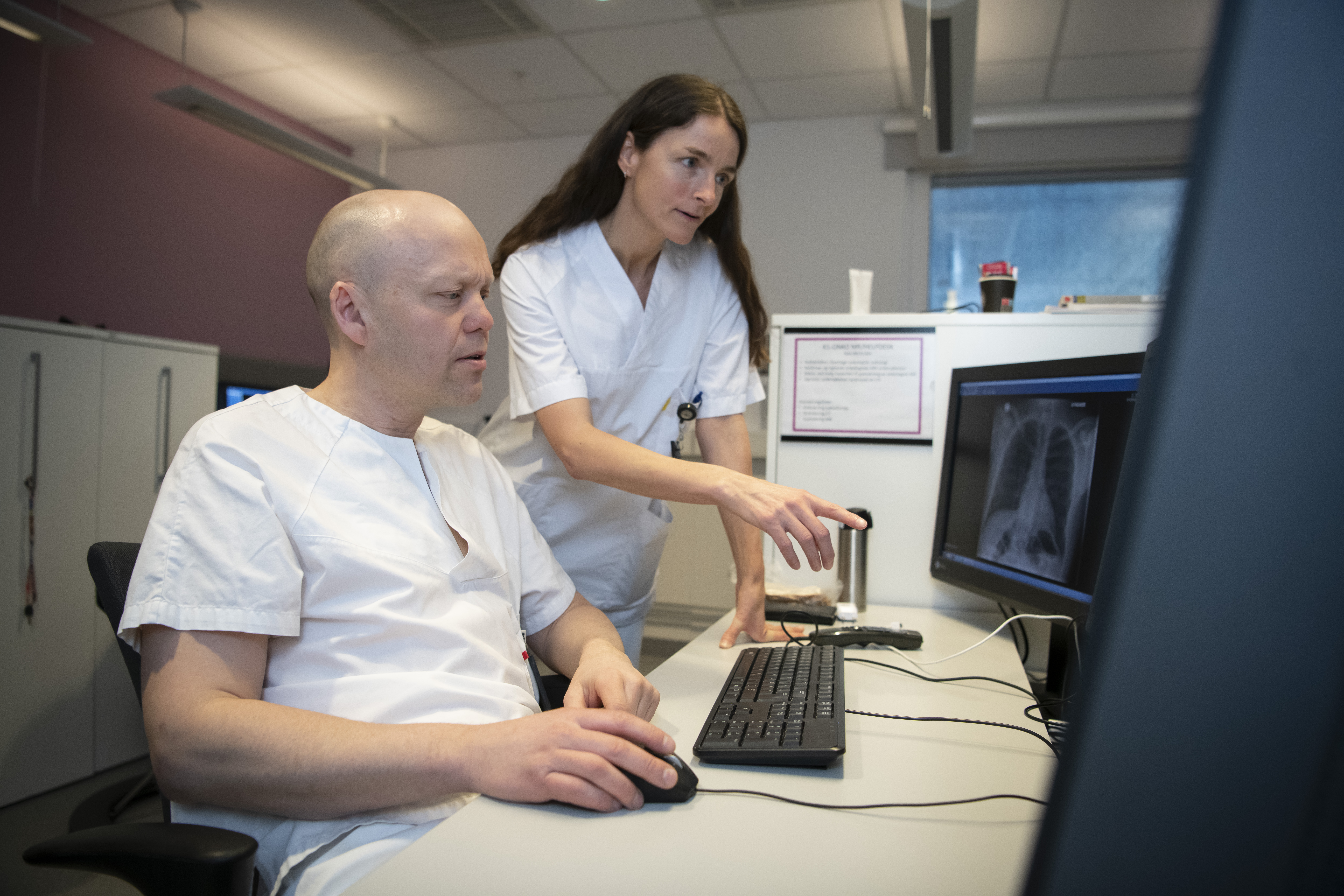 To sykehusansatte ser på radiologibilder på skjerm