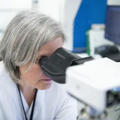 Dame ser i mikroskop