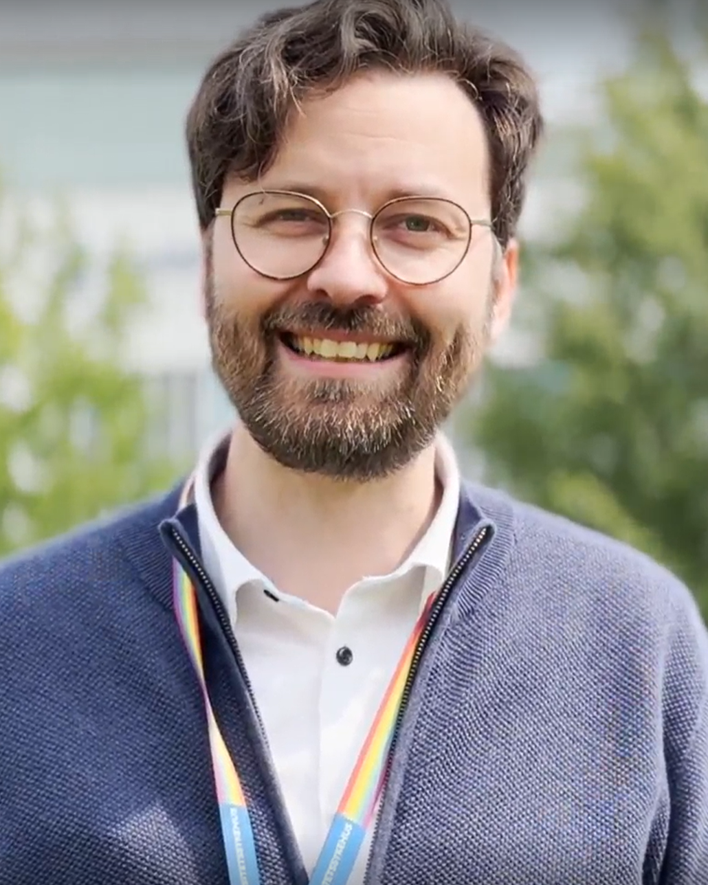 smilende mann med briller og skjegg