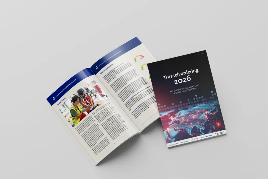 To rapporter på et bord, det ene er oppslått, det andre med forside opp. På forsiden står det "Trusselvurdering 2026". Foto.