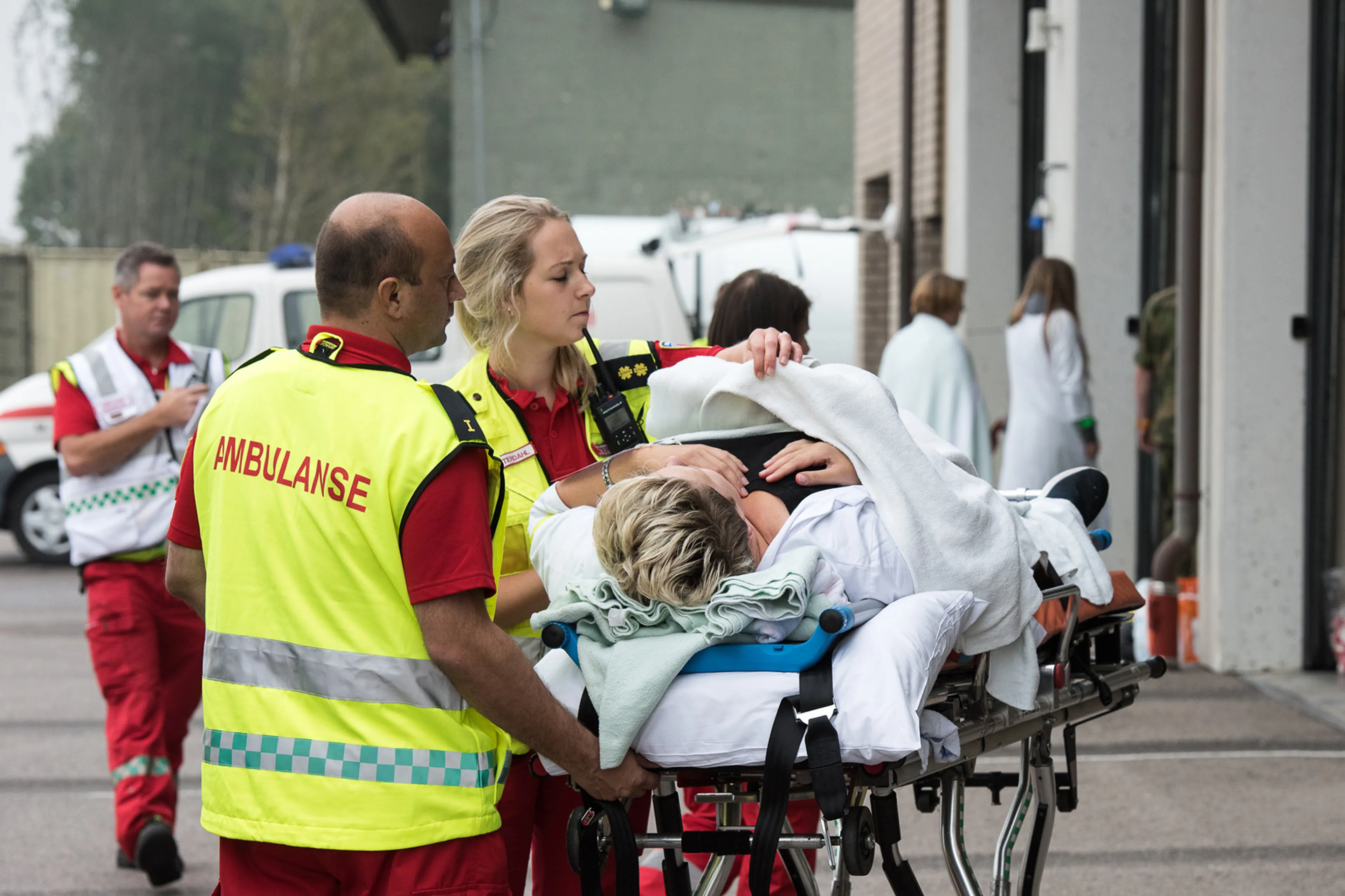 Two paramedics pushing a person on a stretcher. Photo.
