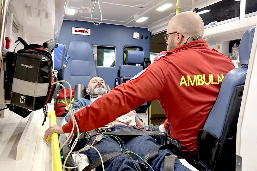 Ambulansemedarbeider og pasient i ambulanse. Foto.