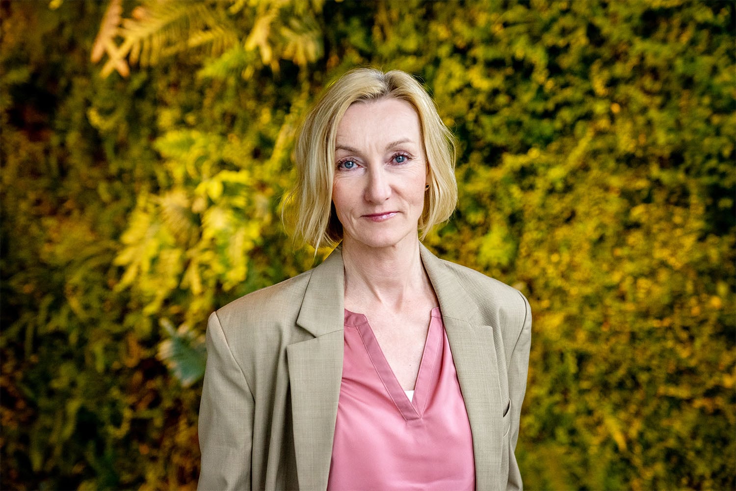 Smiling woman in a beige suite. Photo.