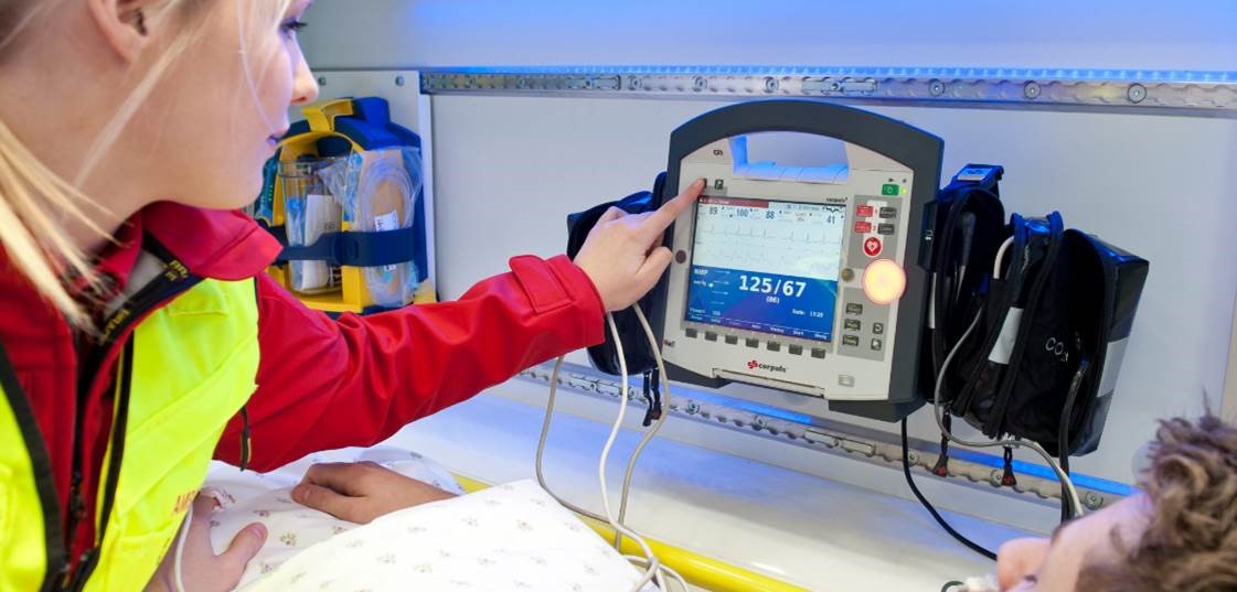 Ambulansepersonell som bruker et medisinsk utstyr