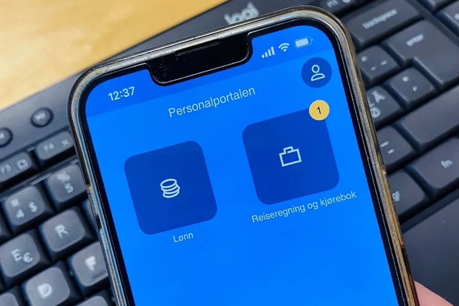 Personalportalen vist på mobilskjerm med tastatur i bakgrunnen. Foto.