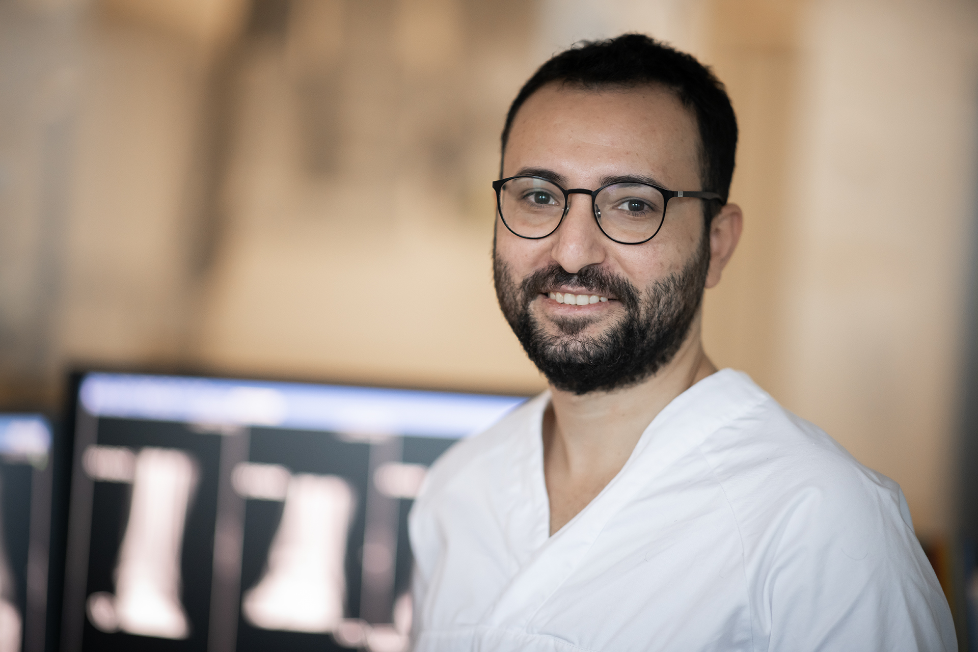 Sykehusansatt med skjermer i bakgrunnen