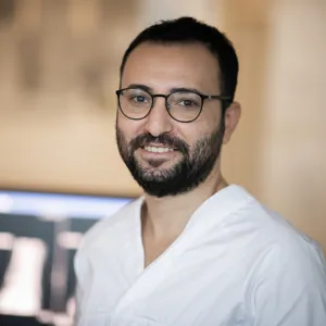 Sykehusansatt med skjermer i bakgrunnen