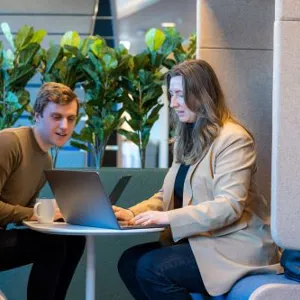 A man and a woman looking at a laptop