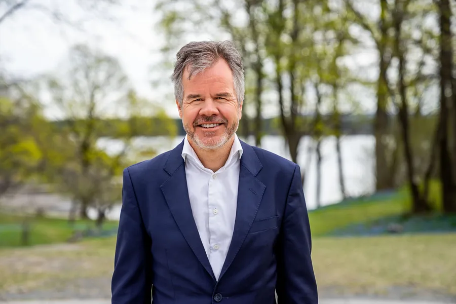 Smilende mann med grått hår og skjegg. Foto.