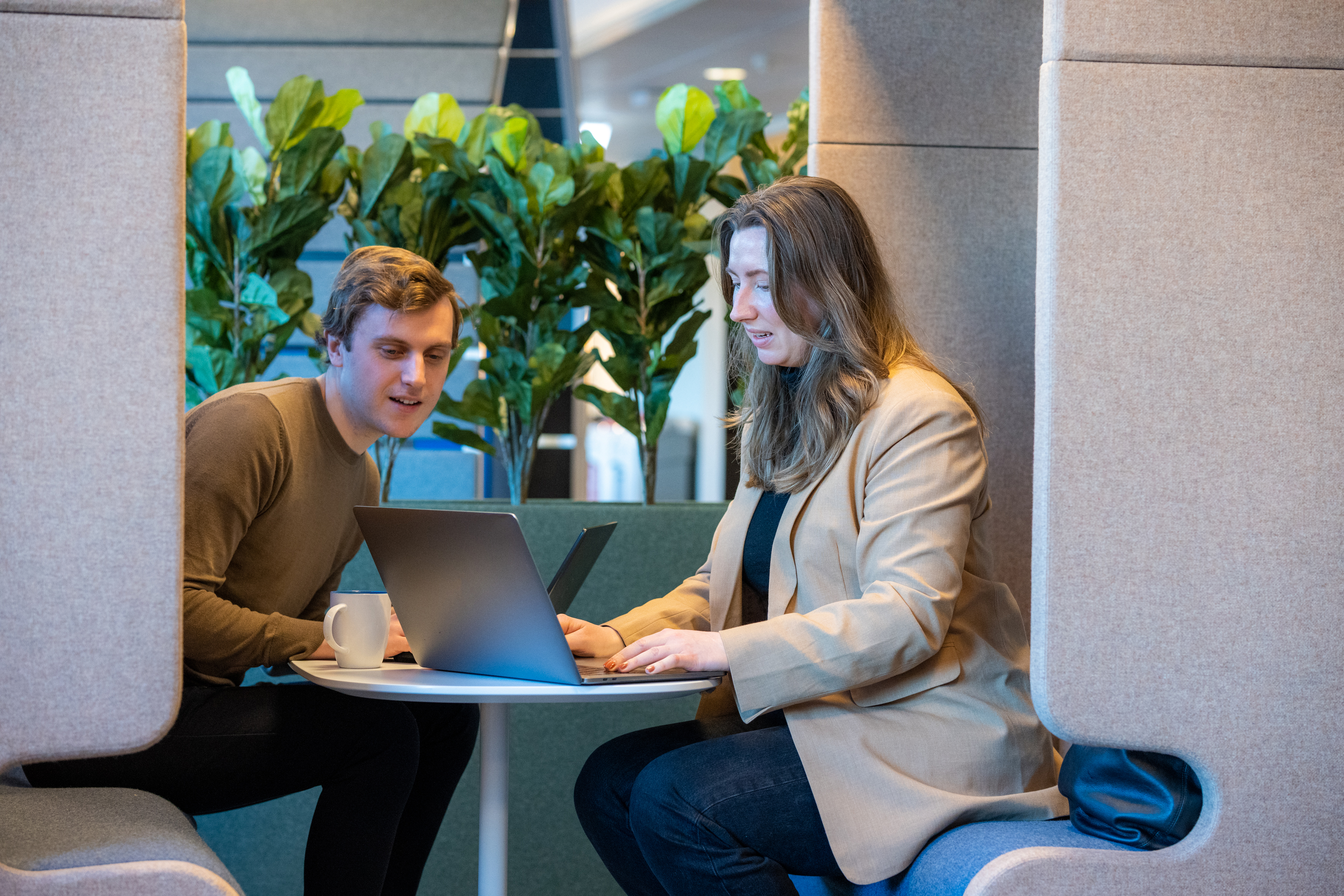 Kvinne og mann i dialog over pc. Foto.