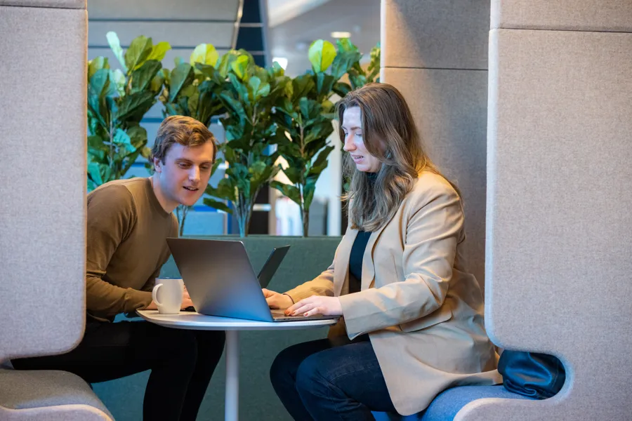 Kvinne og mann i dialog over pc. Foto.