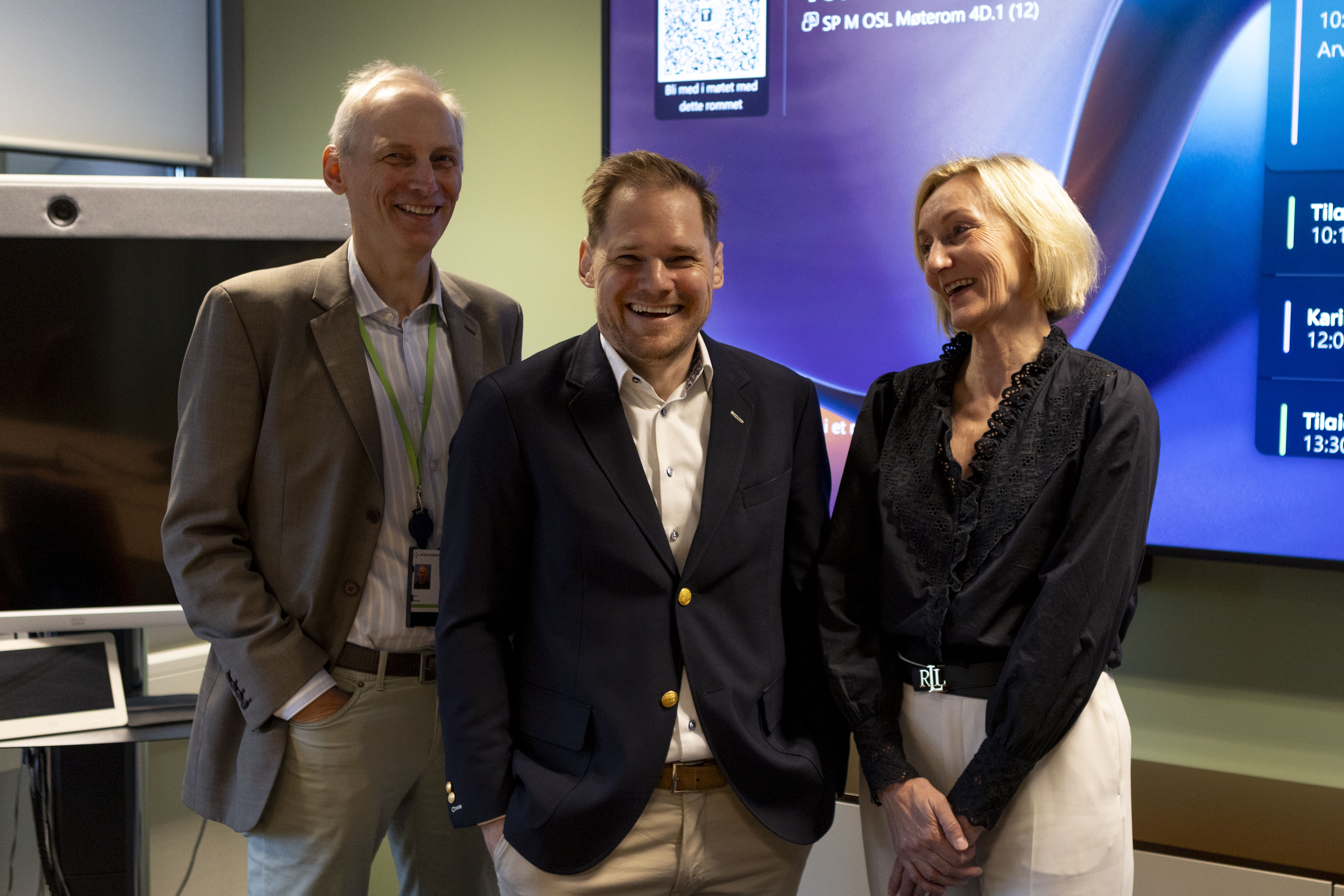 Tre mennesker som står sammen. Foto.