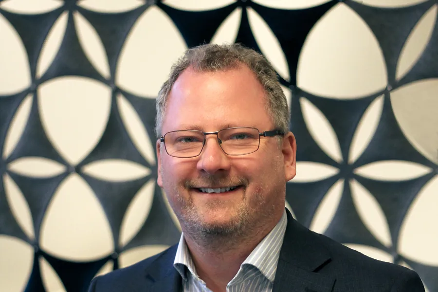 Smilende mann med briller. Foto.