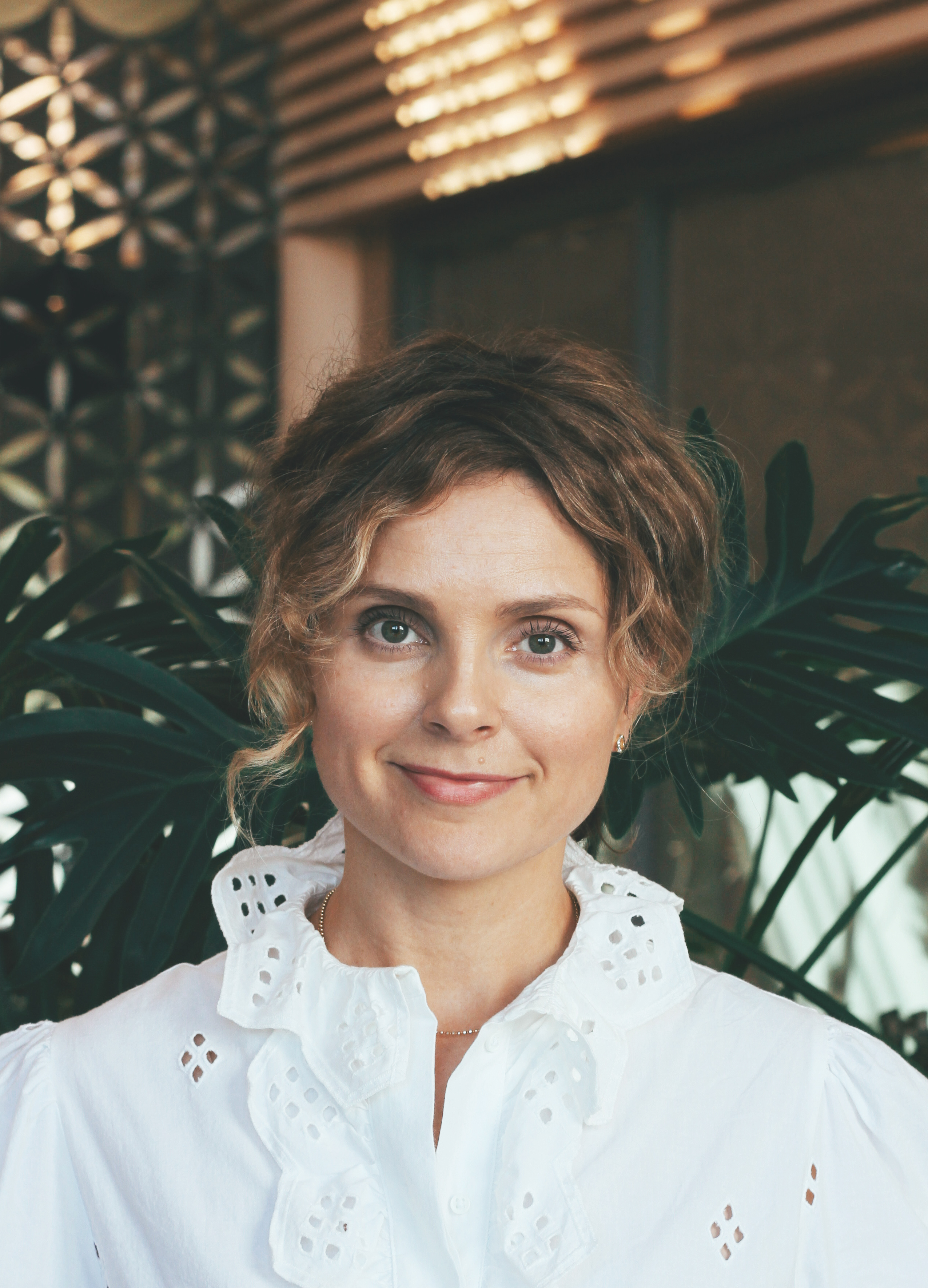 Smilende kvinne med krøllete hår. Foto.