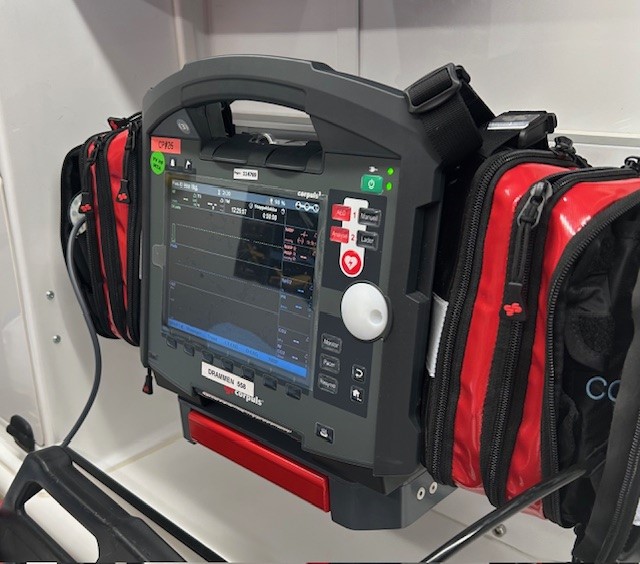 Nærbilde av et teknisk apparat med svart skjerm, håndtak og ledninger. Foto.