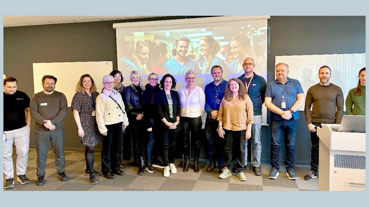 En gruppe mennesker i et møterom som poserer for et bilde. Foto.