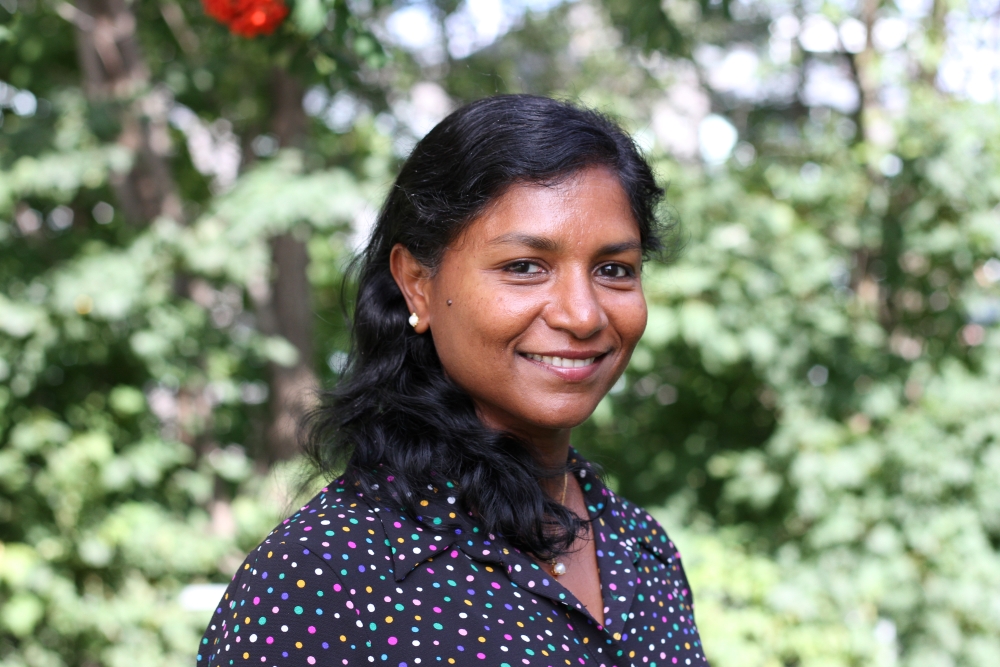 Smilende kvinne med mørkt hår.