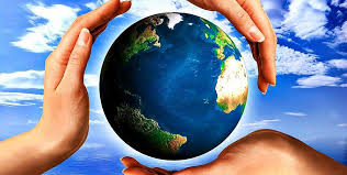 Hender som holder om en jordklode. Blå himmel og skyer i bakgrunn. Foto.