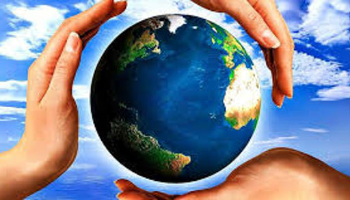 Hender som holder om en jordklode. Blå himmel og skyer i bakgrunn. Foto.