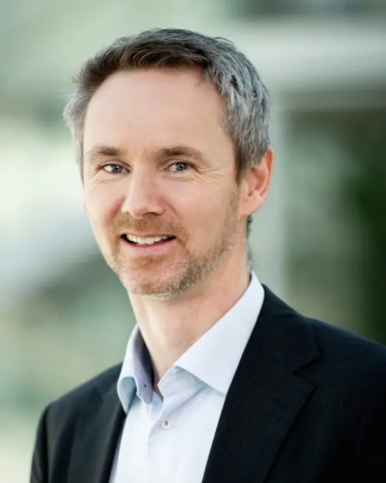 Smilende mann i dress. Foto.