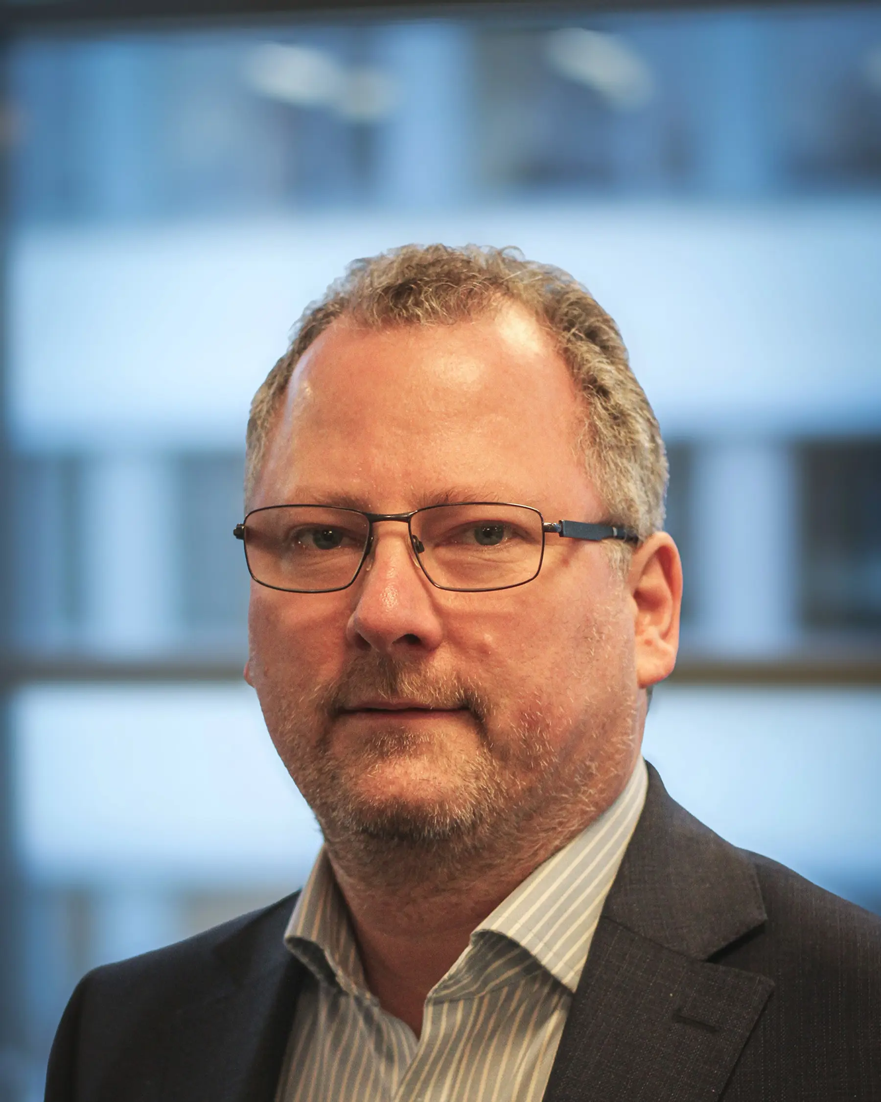 Mann med grått hår og briller. Foto.